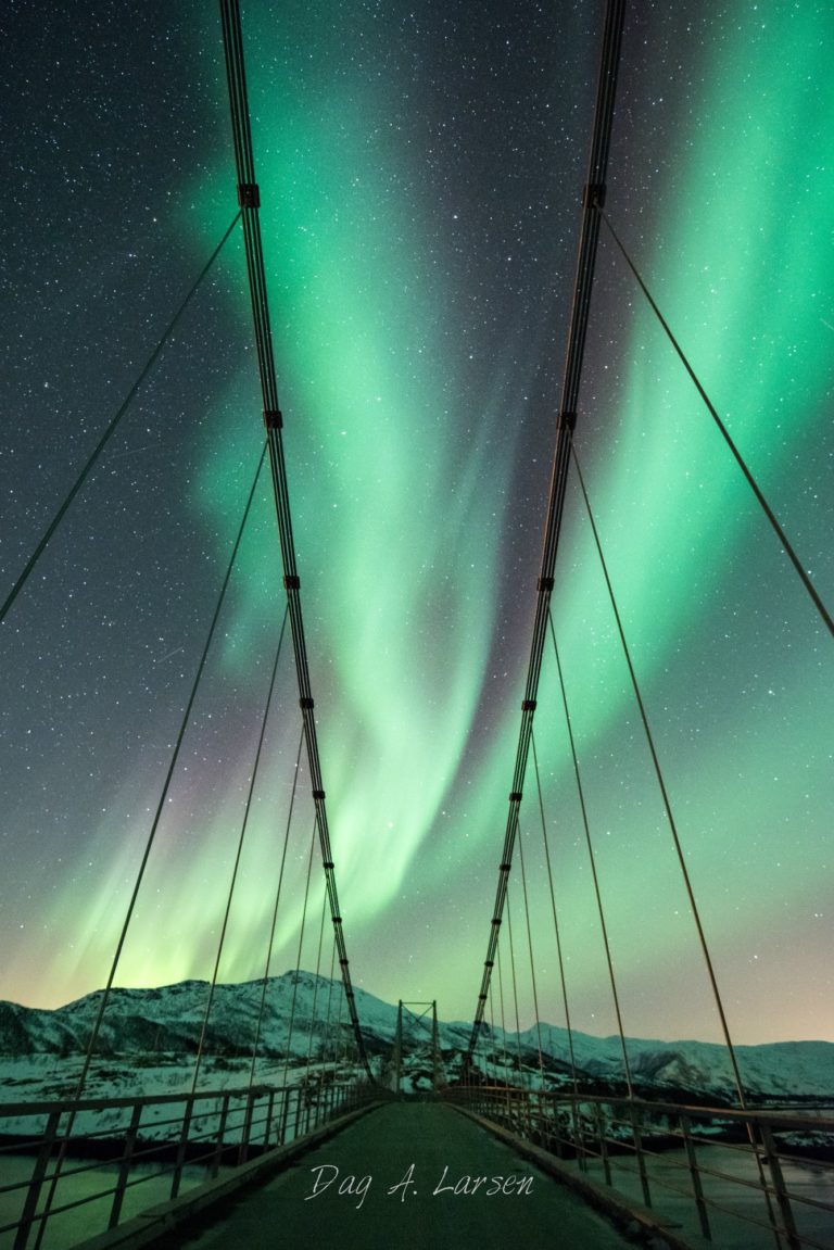 Eine kleine Brücke an der Norwegischen Landschaftsroute auf Senja unter den Nordlichtern © Dag A. Larsen / Hamn i Senja