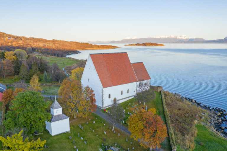 Trondenes church in autumnal colours. Do note the remnants of the defense tower to the right of the church choir © Jan Schmitt/Visit Harstad