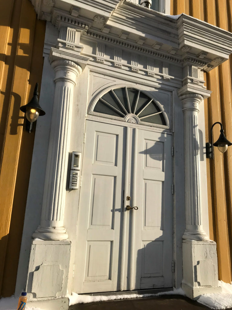 klassiske templer, men alt i tre © Knut Hansvold ChatGPT sa: A magnificent portal at Skippergata 19, with half-columns inspired by classical temples, but all in wood © Knut Hansvold